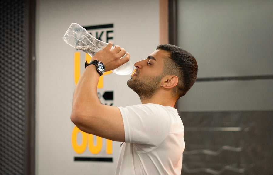 Man drinking water during a break at the gym