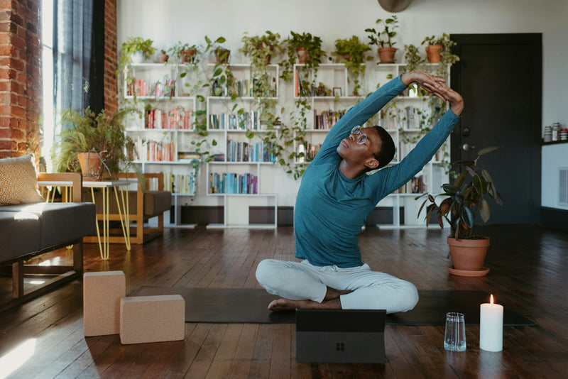 Man doing a full-body stretch in his living room