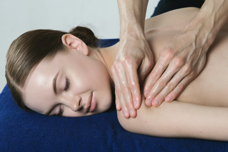 Woman relaxing while her back and shoulders are massaged