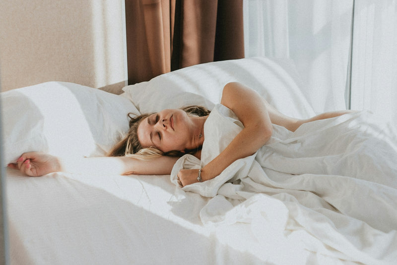 Woman sleeping peacefully in a bright bedroom